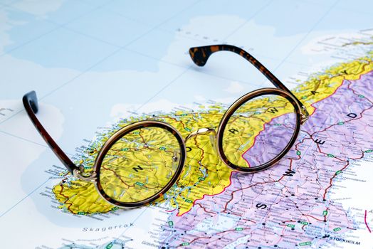 Photo of glasses on a map of europe. Focus on Norway. May be used as illustration for traveling theme.