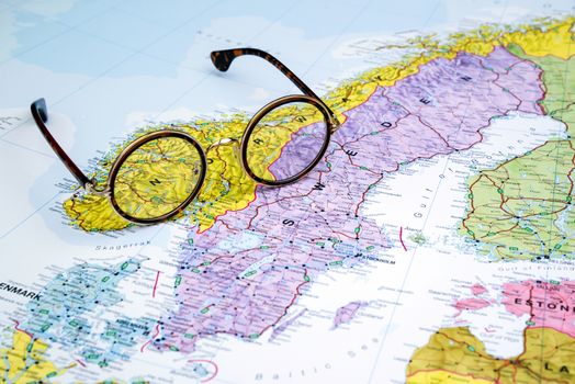 Photo of glasses on a map of europe. Focus on Norway. May be used as illustration for traveling theme.