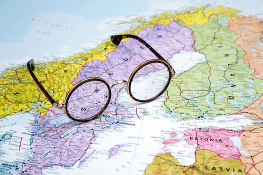 Photo of glasses on a map of europe. Focus on Sweden. May be used as illustration for traveling theme.