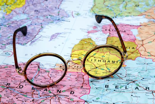 Photo of glasses on a map of europe. Focus on Lithuania. May be used as illustration for traveling theme.