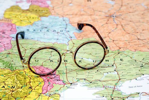 Photo of glasses on a map of europe. Focus on Ukraine. May be used as illustration for traveling theme.