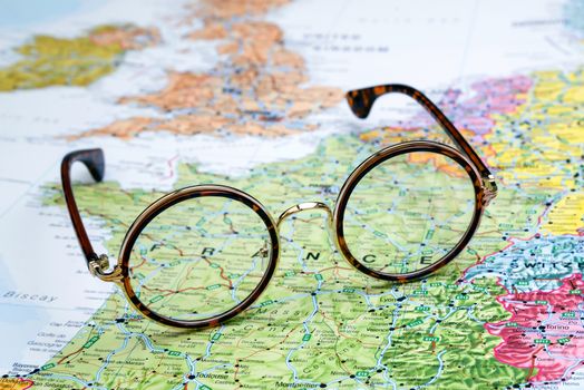 Photo of glasses on a map of europe. Focus on France. May be used as illustration for traveling theme.