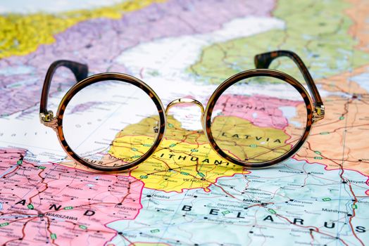 Photo of glasses on a map of europe. Focus on Latvia. May be used as illustration for traveling theme.
