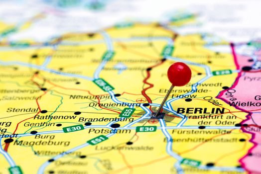 Photo of pinned Berlin on a map of europe. May be used as illustration for traveling theme.