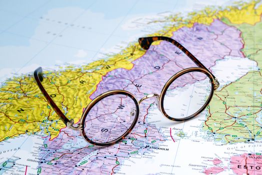 Photo of glasses on a map of europe. Focus on Sweden. May be used as illustration for traveling theme.