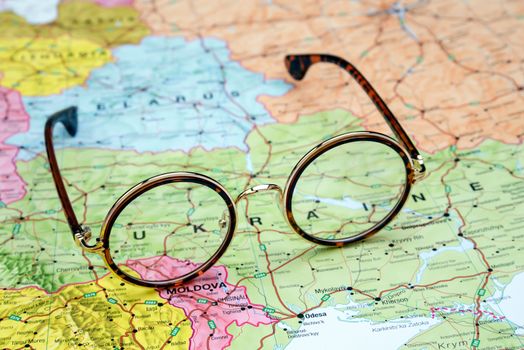 Photo of glasses on a map of europe. Focus on Ukraine. May be used as illustration for traveling theme.
