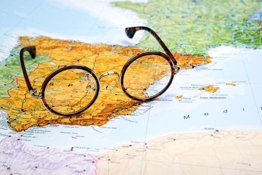 Photo of glasses on a map of europe. Focus on Spain. May be used as illustration for traveling theme.