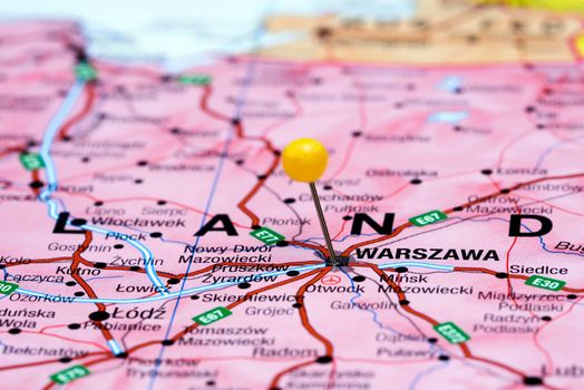 Photo of pinned Warsaw on a map of europe. May be used as illustration for traveling theme.