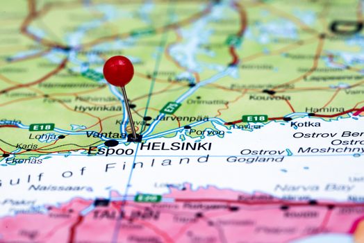 Photo of pinned Helsinki on a map of europe. May be used as illustration for traveling theme.