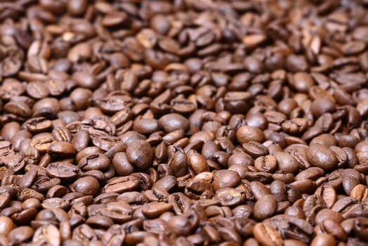 Photo of a heap of brown coffee beans. May be used for for background and texture. Food photography.