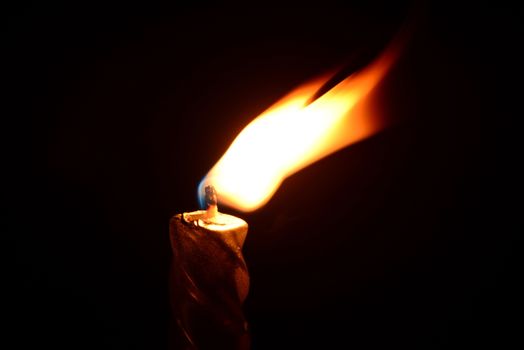 Photo of a silver candle burning on a black background. Objects photography.