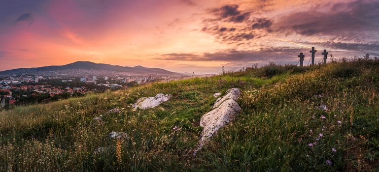 Village under a Hill at Sunset. Meadow with Flowers and Rocks in Foreground. Calvary, Nitra, Slovakia