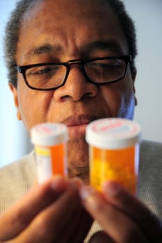 Black man taking medicine for high blood pressure.