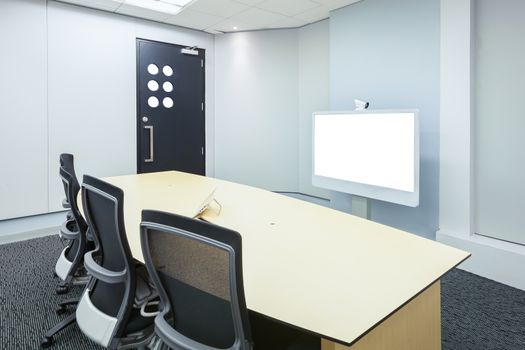 teleconferencing, video conference and telepresence business meeting room with white blank display screen