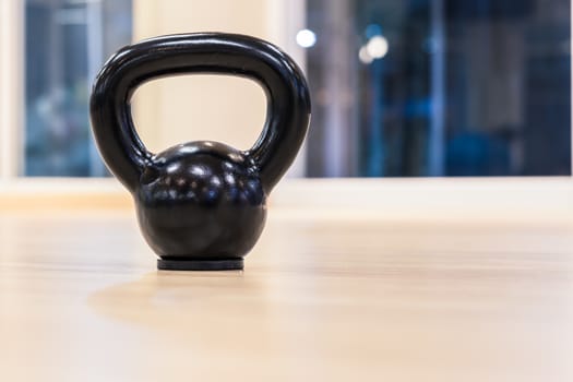 black iron kettlebell weight on wooden floor