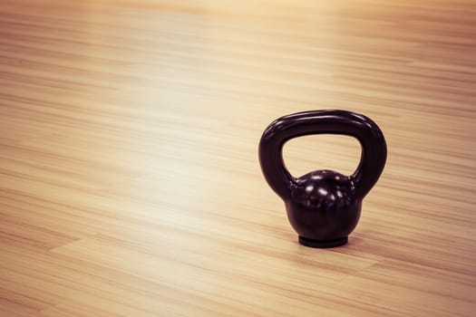 black iron kettlebell weight on wooden floor