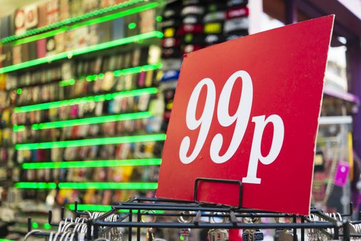 Detail of 99p sign with neon lights in the background