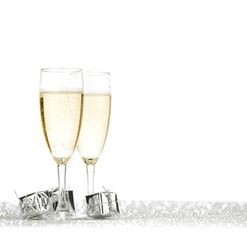 Glasses of champagne and christmas gifts on silver background