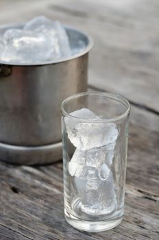 Glass with ice cubes and Ice bucket filled with ice cubes