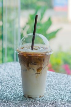 Iced coffee with straw in plastic cup for take aways