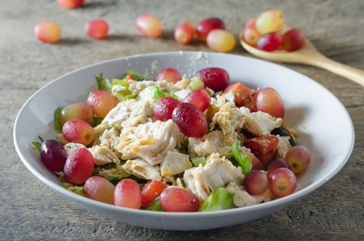 Mix salad with grapes and chicken on white dish