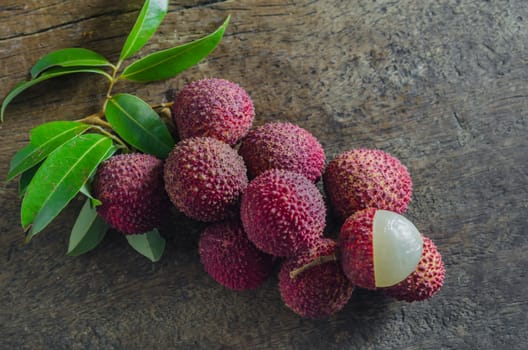 Lychee with leaves on a wooden table