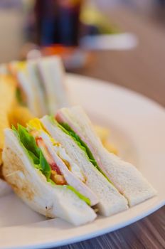 Delicious club sandwich with french fries at a dinner