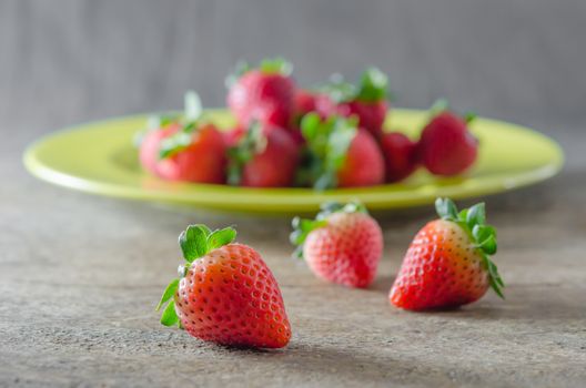 still life of fresh red strawberries on dish over wooden background