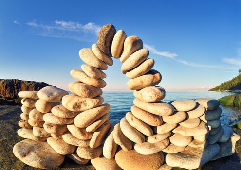 Arch of pebbles between of the stones on the coast