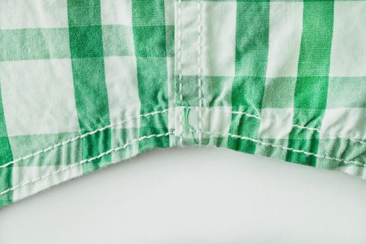 Edge of a green and white checked cotton shirt