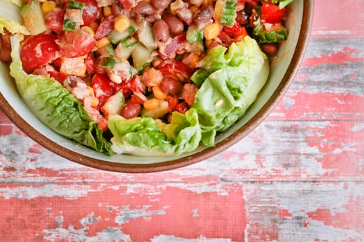 A freshly made salad in a dish on a wooden surface