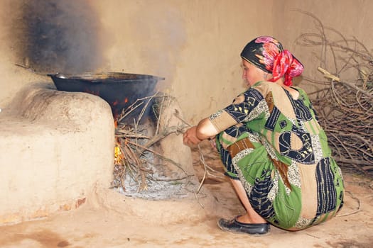 HISSAR MOUNTAINS, UZBEKISTAN - MAY 24, 2012: Woman cooking on traditional method on May 24, 2012 in Uzbekistan, Asia.