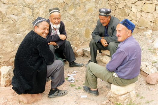 HISSAR MOUNTAINS, UZBEKISTAN - MAY 24, 2012: Men playing at cards in a small village of Hissar Mountains on May 24, 2012 in Uzbekistan, Asia.                    