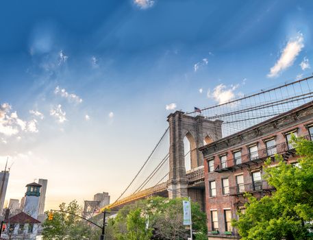 Brooklyn Bridge as seen from Brooklyn streets at sunset time.