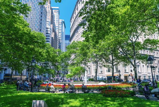 NEW YORK CITY - MAY 14, 2013: Tourists relax on a city park. More than 50 million people visit the city annually.