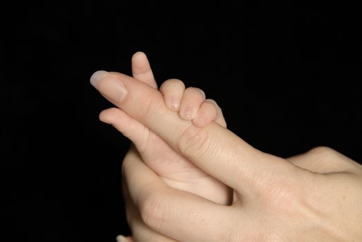 Five week old baby holding mothers finger.