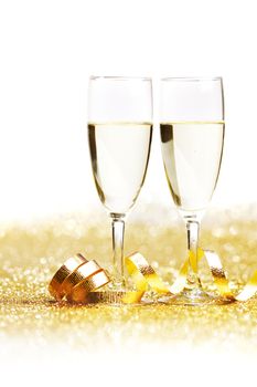 Two glasses of champagne with bow on golden background