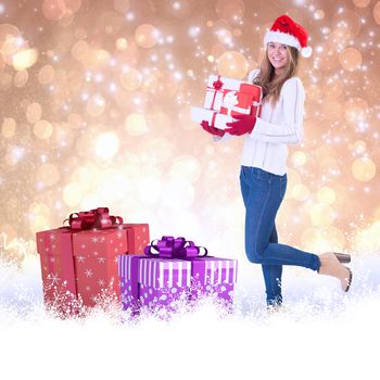 Festive blonde holding pile of gifts against yellow abstract light spot design