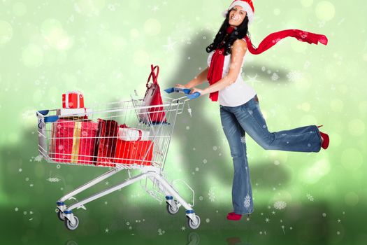 Woman standing with shopping trolley against green abstract light spot design