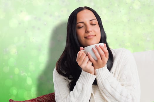 Woman enjoying a lovely drink against green abstract light spot design