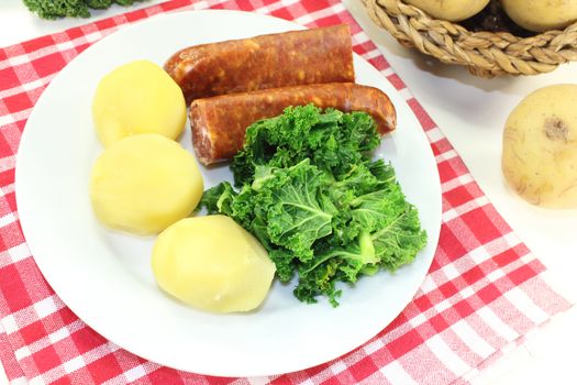 a white plate with kale and pee sausage