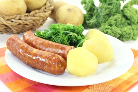 a white plate with kale and pee sausage