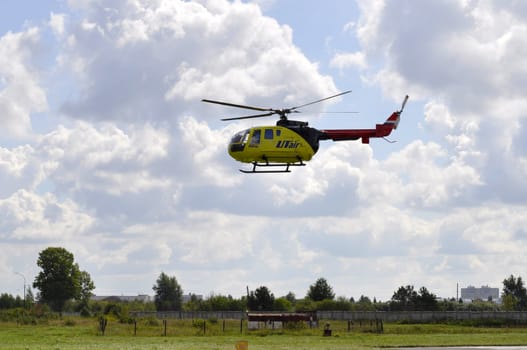The small yellow helicopter of Utair airline in the sky