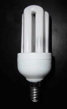 Close up view of a compact fluorescent light-bulb on a black wooden table.

Picture taken on November 5, 2014.