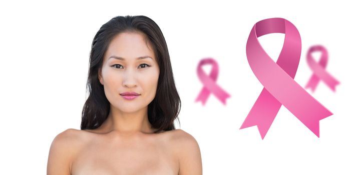 Attractive nude brunette posing looking  against pink breast cancer awareness ribbons