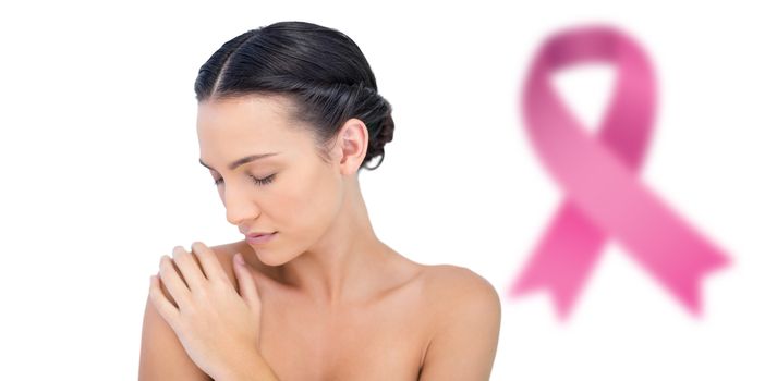 Natural model posing eyes closed against breast cancer awareness ribbon