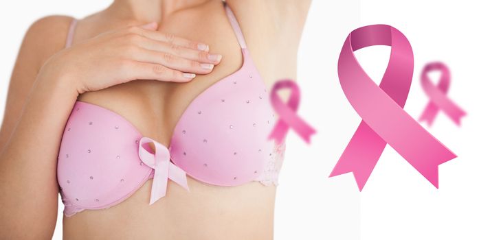 Woman in bra with breast cancer awareness ribbon against pink breast cancer awareness ribbons