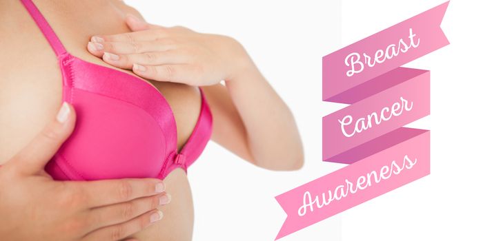 Closeup of woman performing self breast examination against breast cancer awareness message