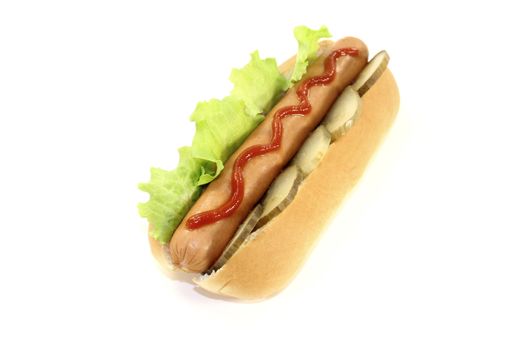 Hot dog with pickle, lettuce, sausage and ketchup