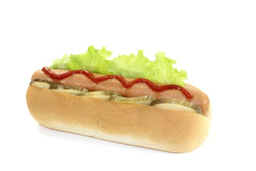 Hot dog with pickle, lettuce leaf, sausage and ketchup